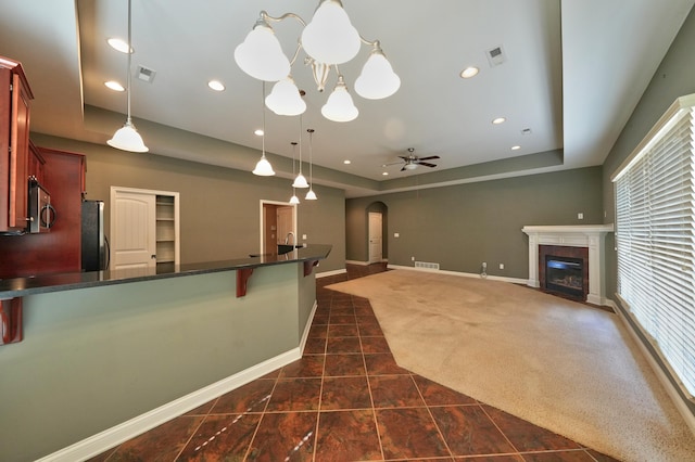 interior space featuring ceiling fan with notable chandelier and a premium fireplace