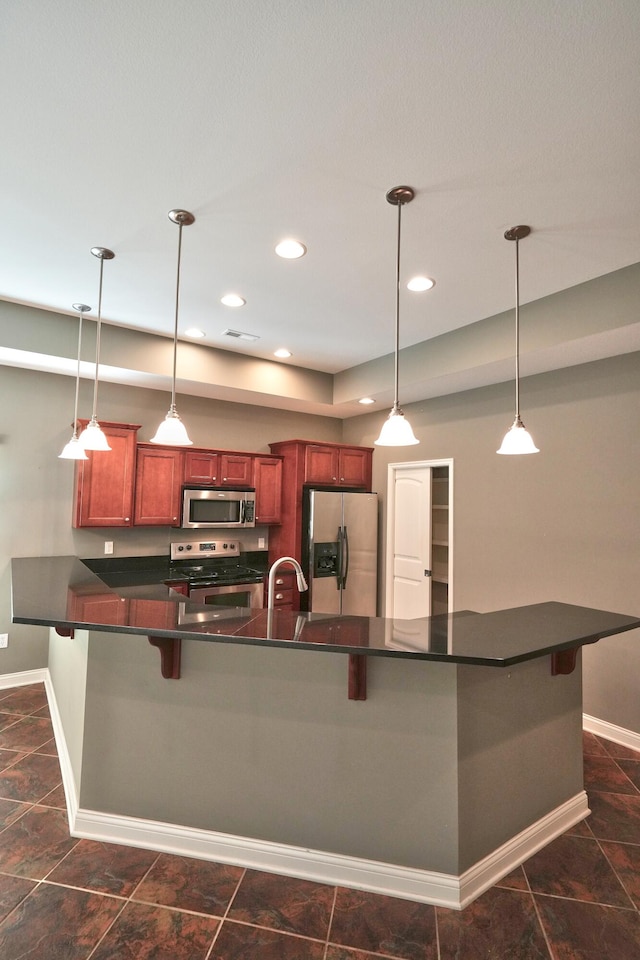 kitchen with pendant lighting, a breakfast bar area, and stainless steel appliances