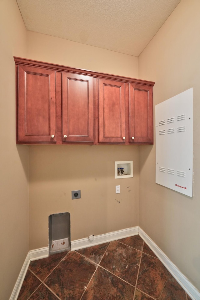 laundry area with hookup for a washing machine, hookup for an electric dryer, a textured ceiling, cabinets, and gas dryer hookup