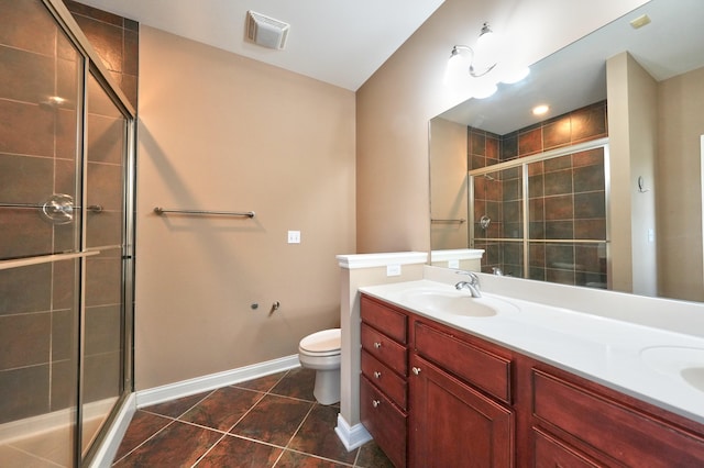 bathroom with vanity, toilet, tile patterned floors, and a shower with door