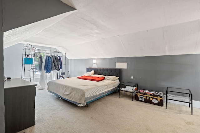 bedroom with vaulted ceiling and carpet floors