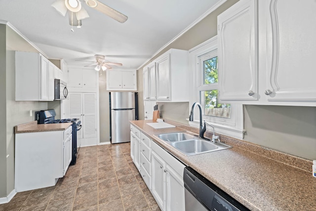 kitchen featuring appliances with stainless steel finishes, white cabinets, crown molding, ceiling fan, and sink