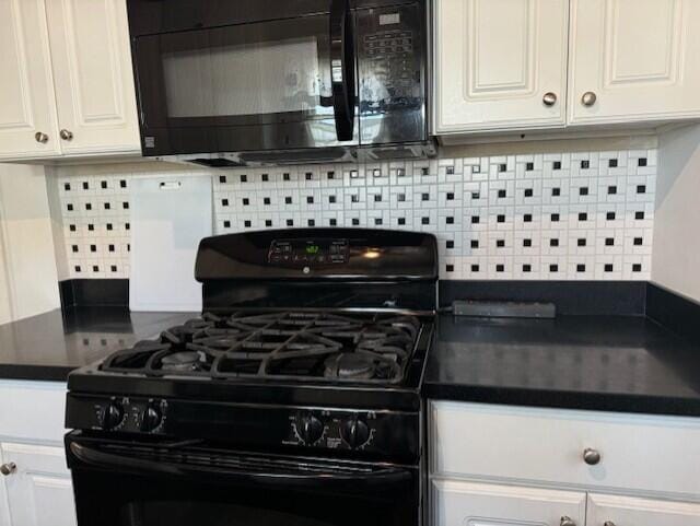 kitchen featuring white cabinets, black appliances, and tasteful backsplash