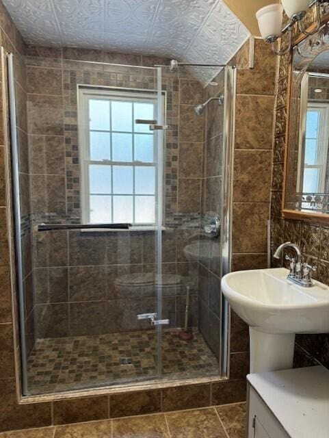 bathroom featuring tile walls, sink, and an enclosed shower