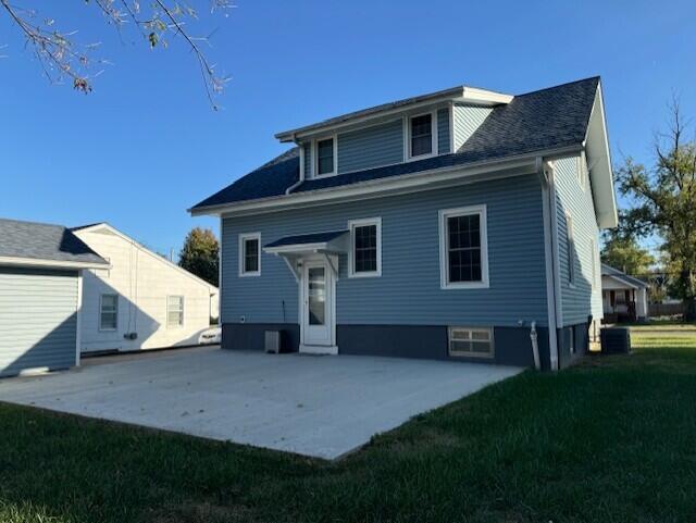 back of house with a lawn, a patio area, and central AC