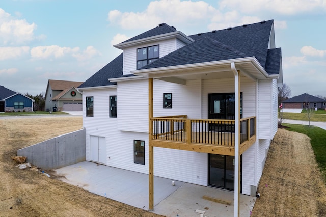 rear view of house with a garage and a patio area