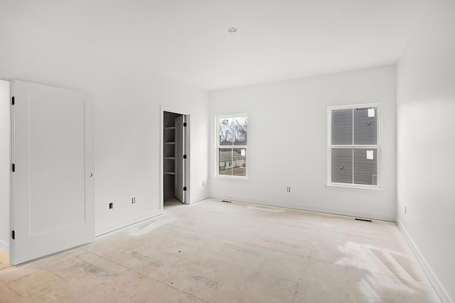 unfurnished bedroom featuring a spacious closet