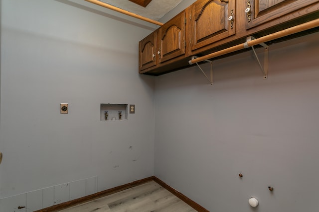 laundry room featuring light wood-type flooring, electric dryer hookup, washer hookup, and cabinets