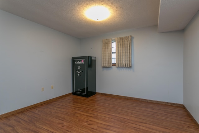 unfurnished room featuring a textured ceiling and hardwood / wood-style flooring