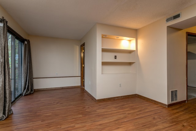 unfurnished room featuring hardwood / wood-style floors and a textured ceiling