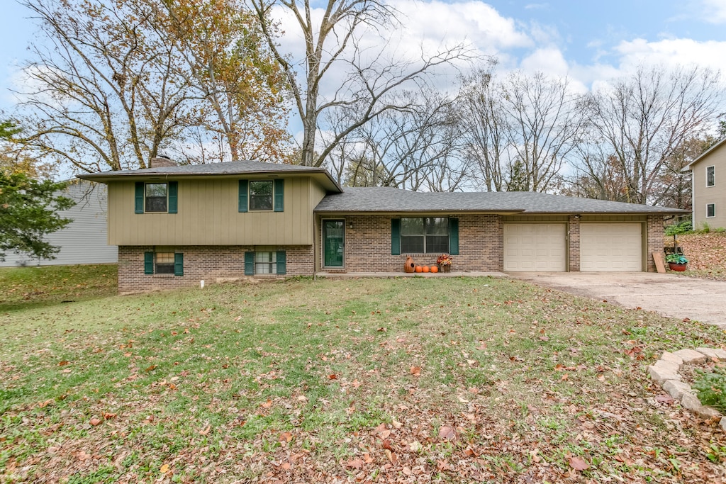 split level home with a garage and a front yard