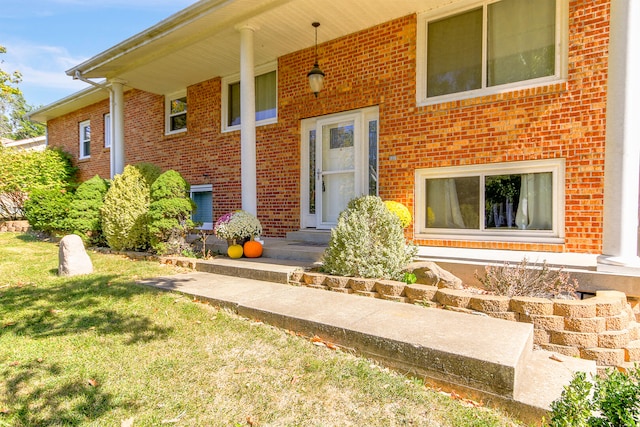 entrance to property featuring a lawn