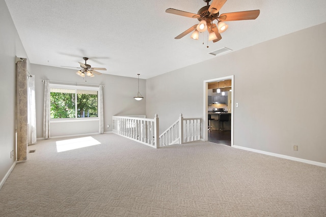 spare room with carpet floors, a textured ceiling, and ceiling fan