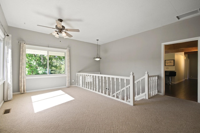 carpeted spare room featuring ceiling fan