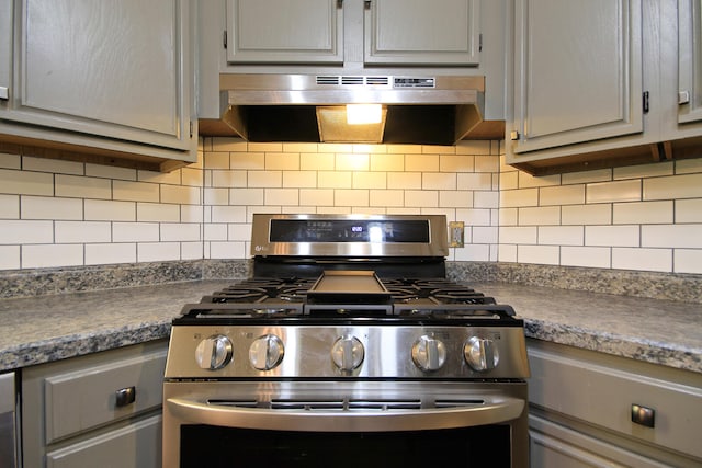 kitchen featuring range hood, gray cabinets, stainless steel range with gas cooktop, and decorative backsplash