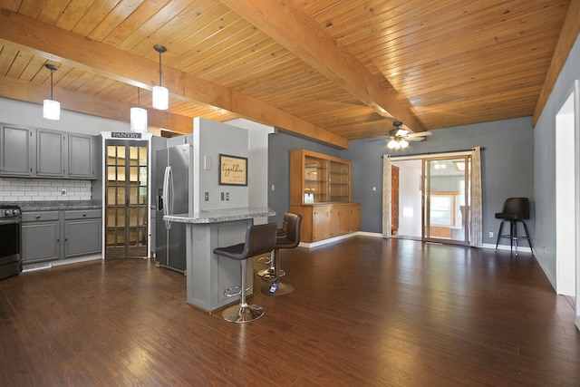 kitchen featuring dark wood-type flooring, hanging light fixtures, stainless steel appliances, and tasteful backsplash