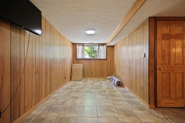 interior space with a textured ceiling and wooden walls