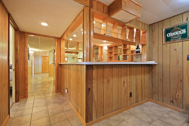 bar with light tile patterned flooring, wooden walls, and built in features