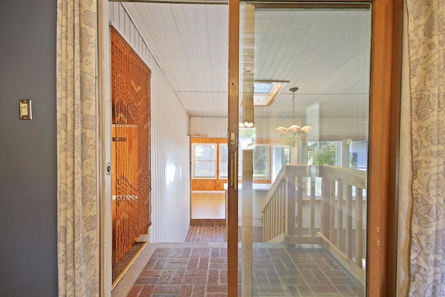 corridor featuring a skylight and an inviting chandelier