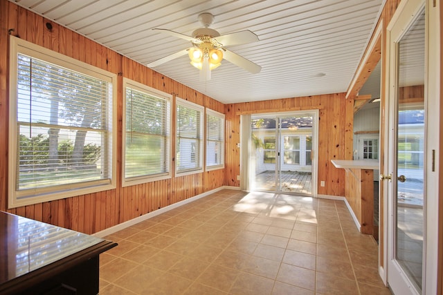 unfurnished sunroom featuring plenty of natural light, wooden ceiling, and ceiling fan