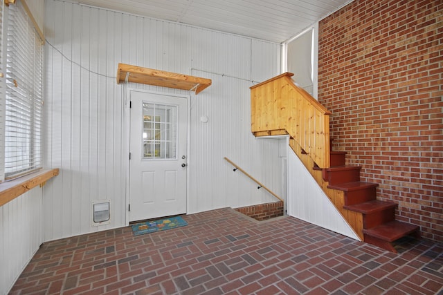 interior space with wood walls and brick wall