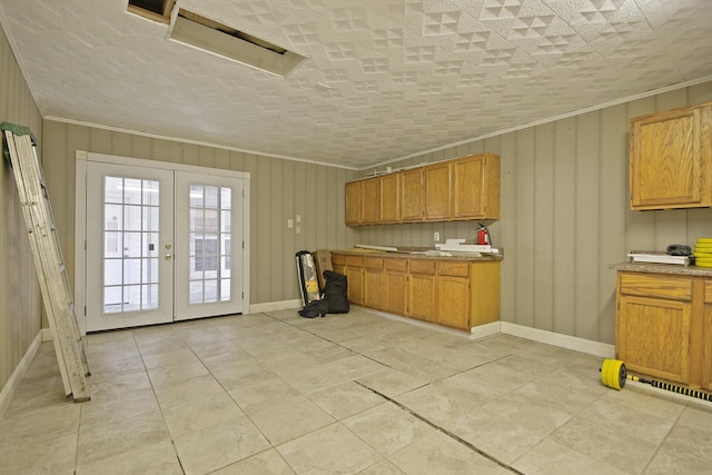 kitchen with wooden walls, french doors, crown molding, light tile patterned floors, and a textured ceiling