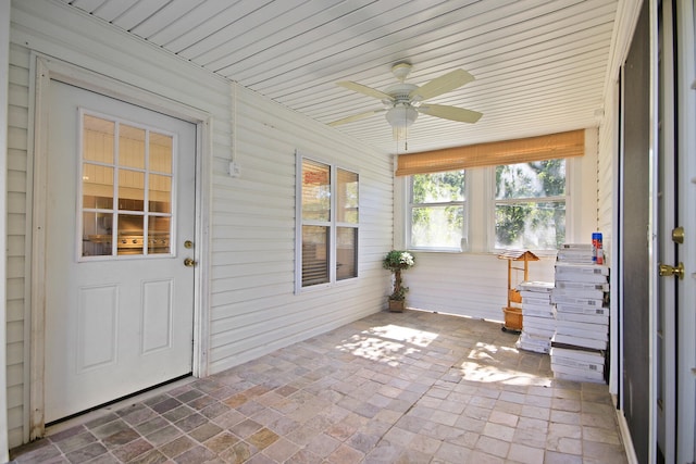 unfurnished sunroom with wooden ceiling and ceiling fan