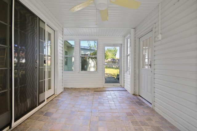 unfurnished sunroom with ceiling fan