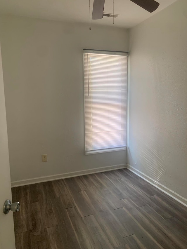 empty room with dark hardwood / wood-style flooring and ceiling fan