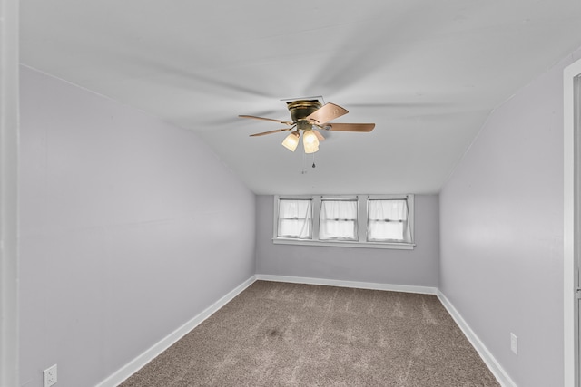 carpeted spare room featuring ceiling fan and vaulted ceiling