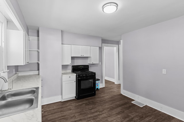 kitchen with gas stove, white cabinets, sink, and dark hardwood / wood-style flooring