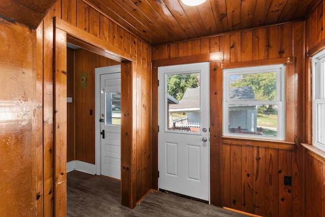 doorway featuring dark wood-type flooring, wood ceiling, and wooden walls