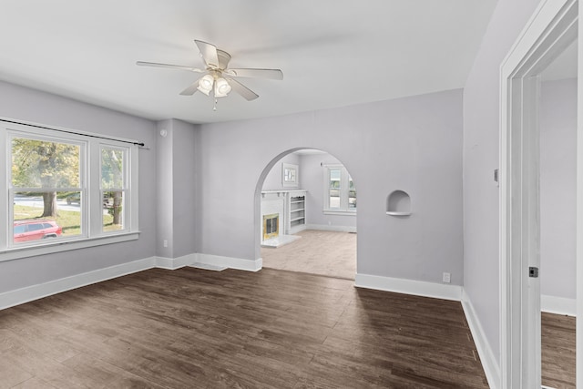 unfurnished room featuring ceiling fan, plenty of natural light, and dark hardwood / wood-style floors