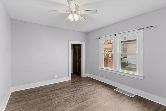 unfurnished room featuring dark wood-type flooring and ceiling fan