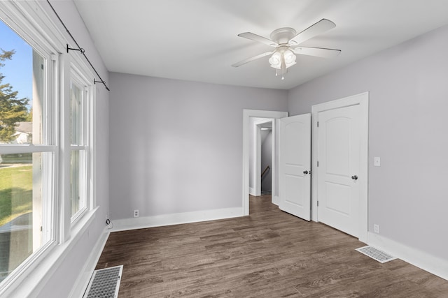 unfurnished bedroom with ceiling fan and dark hardwood / wood-style flooring