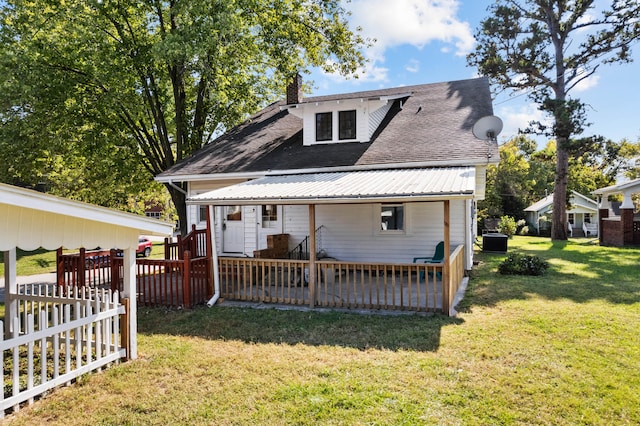 rear view of property featuring central air condition unit, a wooden deck, and a lawn