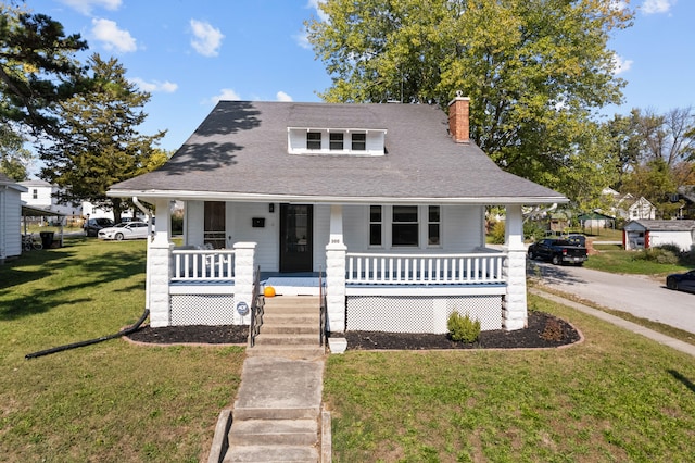 bungalow with a front lawn and covered porch