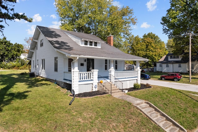 bungalow-style house featuring a front lawn, covered porch, and central air condition unit