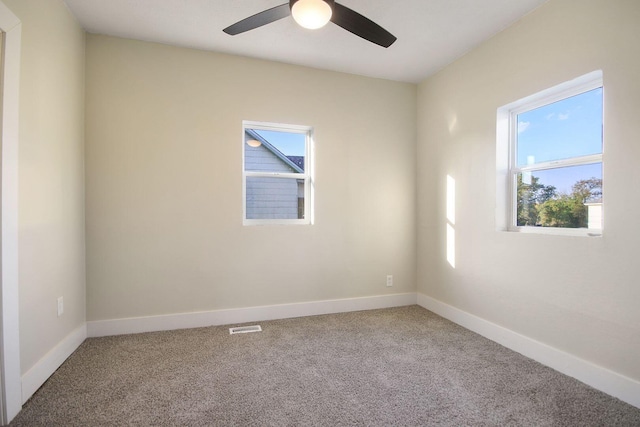 carpeted spare room featuring ceiling fan