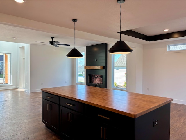 kitchen featuring wood counters, a kitchen island, pendant lighting, and wood finished floors