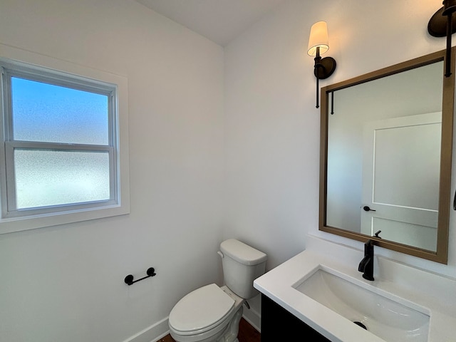 bathroom with baseboards, vanity, and toilet