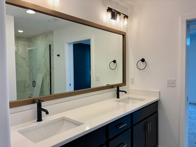 bathroom with double vanity, a marble finish shower, a sink, and recessed lighting