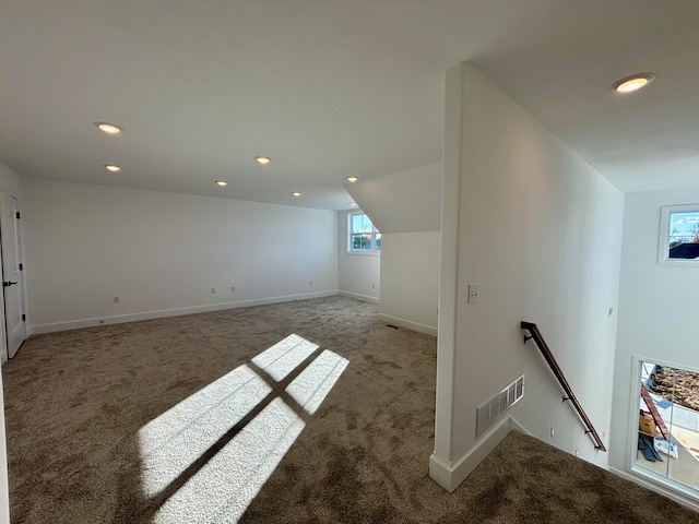 additional living space with baseboards, visible vents, carpet flooring, and recessed lighting