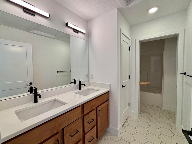 full bath featuring double vanity, shower / bathing tub combination, a sink, and tile patterned floors