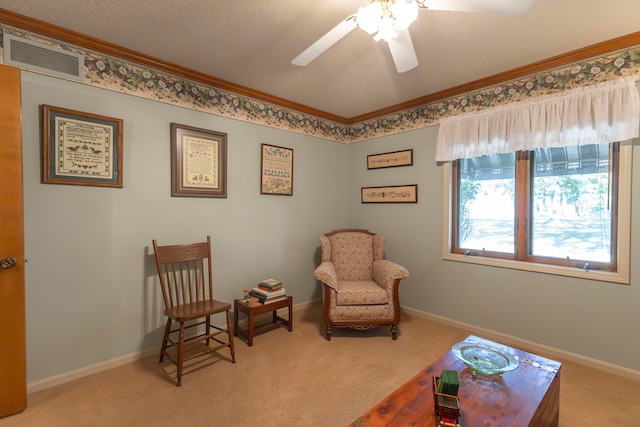 living area featuring ceiling fan, a textured ceiling, crown molding, and carpet