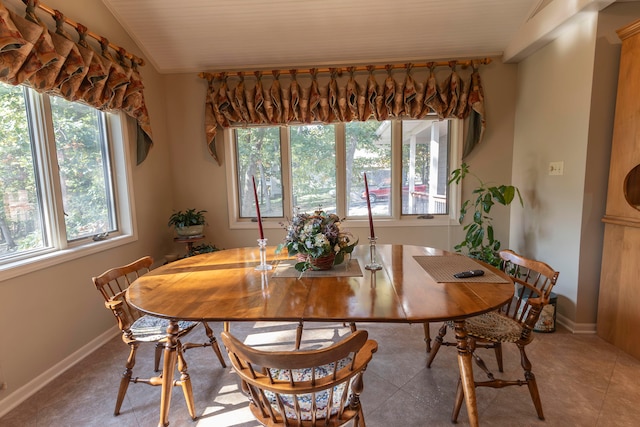 dining space featuring lofted ceiling and tile patterned floors