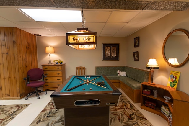 rec room featuring wood walls and a paneled ceiling