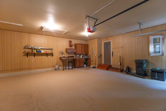 garage with a garage door opener and wood walls