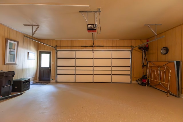 garage featuring a garage door opener and wooden walls