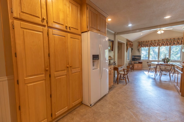 kitchen with ceiling fan, lofted ceiling, white refrigerator with ice dispenser, and a textured ceiling